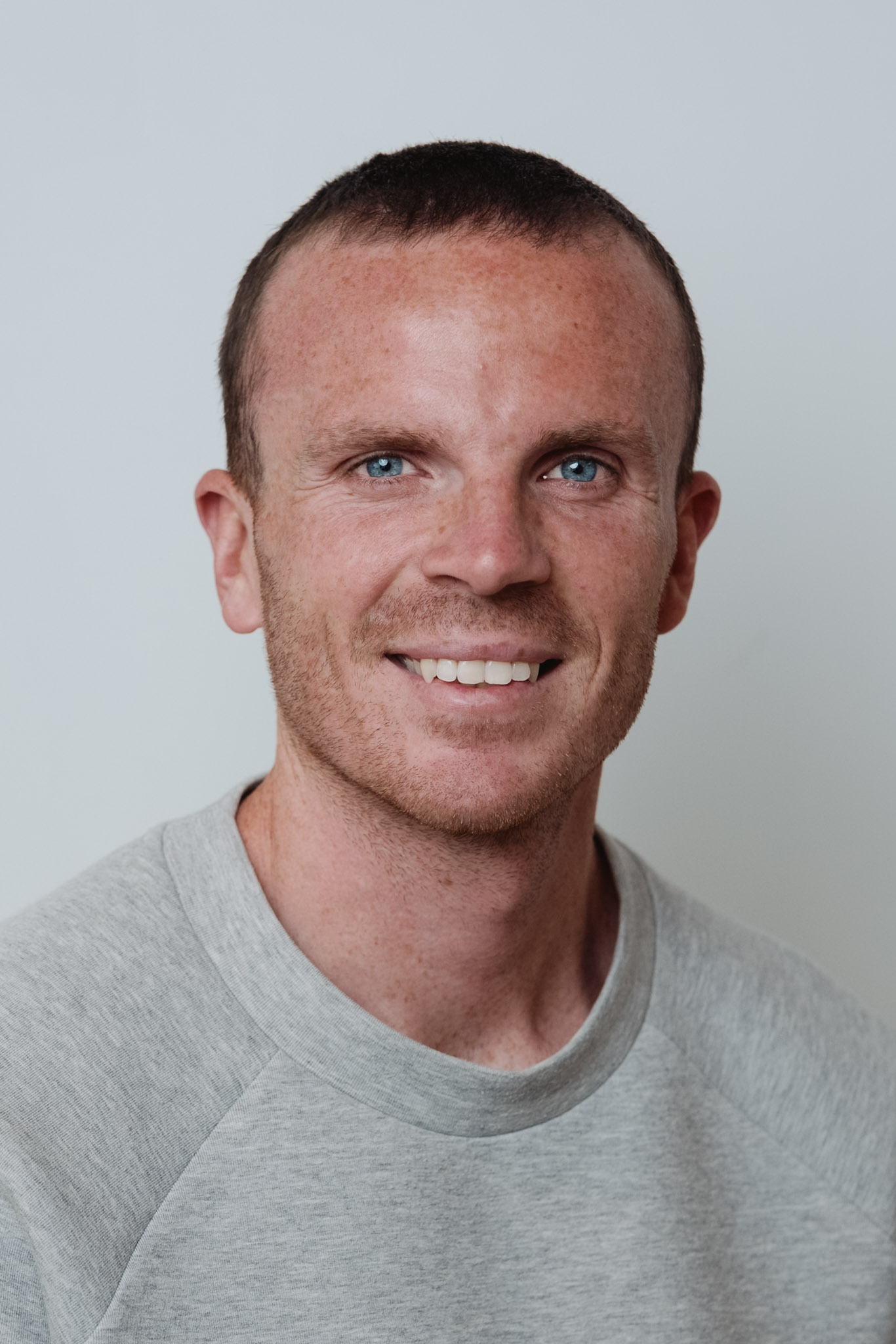 Corporate headshot — professional studio portrait, clean background.