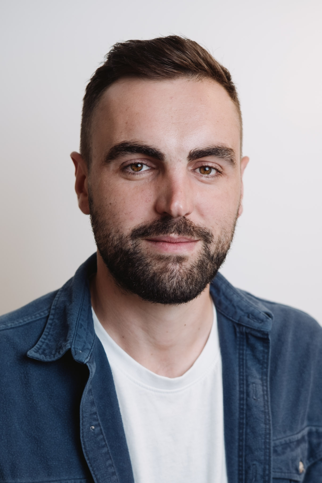 Corporate headshot — clean neutral studio portrait.