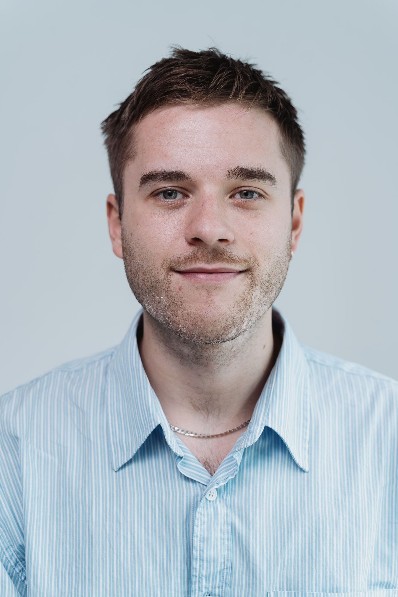 Professional headshot — warm natural expression, studio setting.